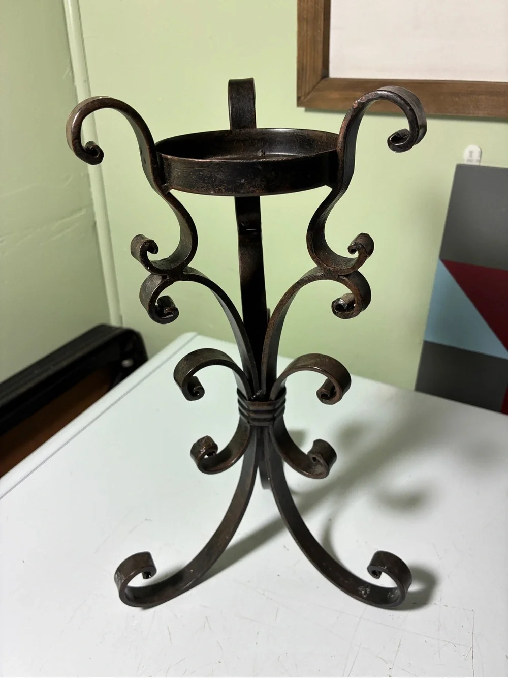 vintage wrought iron candle holder features a dark metal scroll and ring design